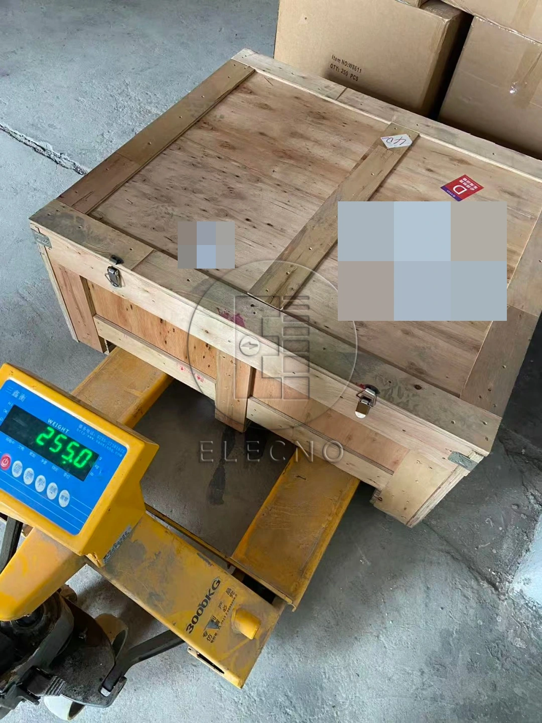 Battery shipping crate on weighing equipment during preparation, with customer identifiers obscured